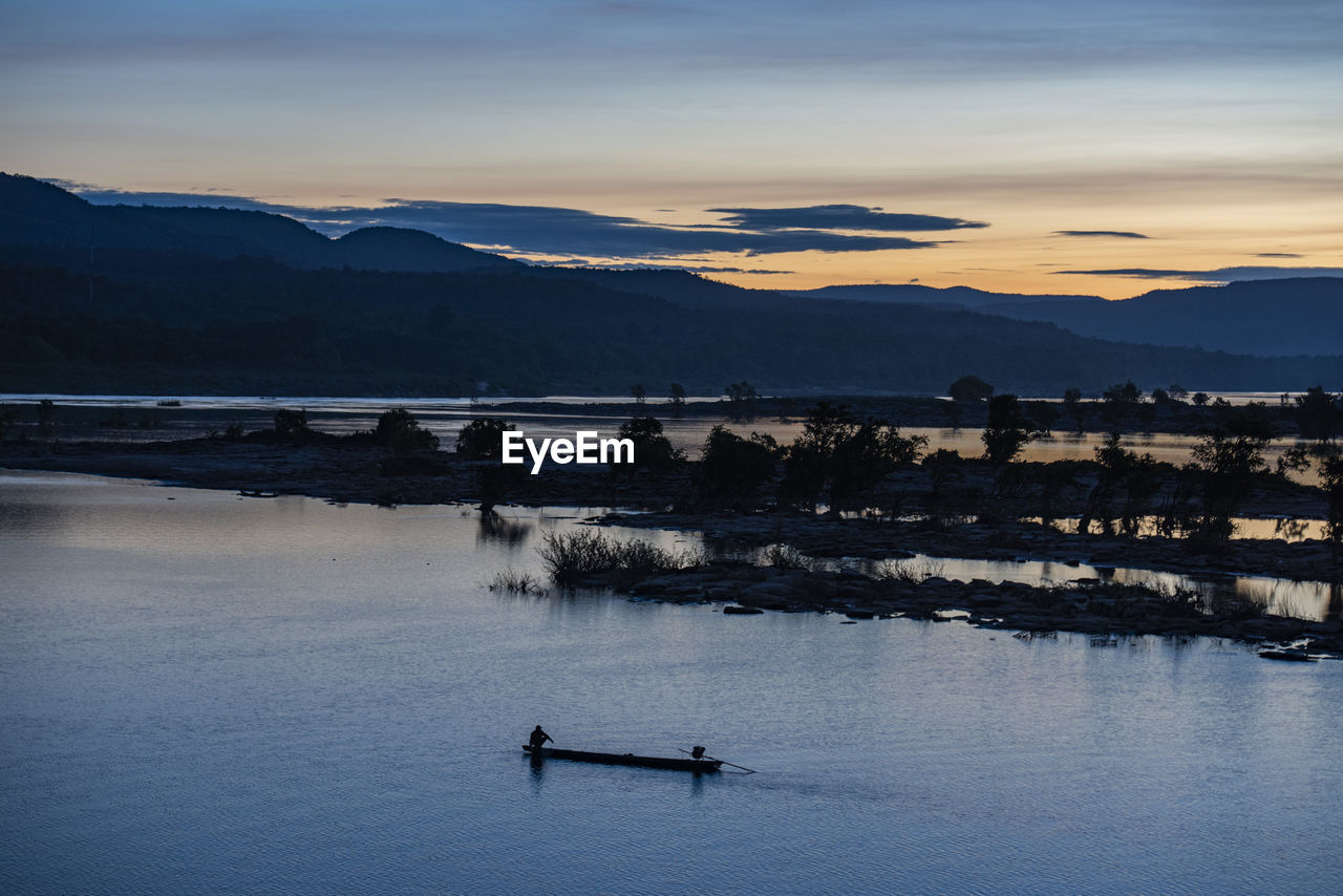 scenic view of lake against sky at sunset