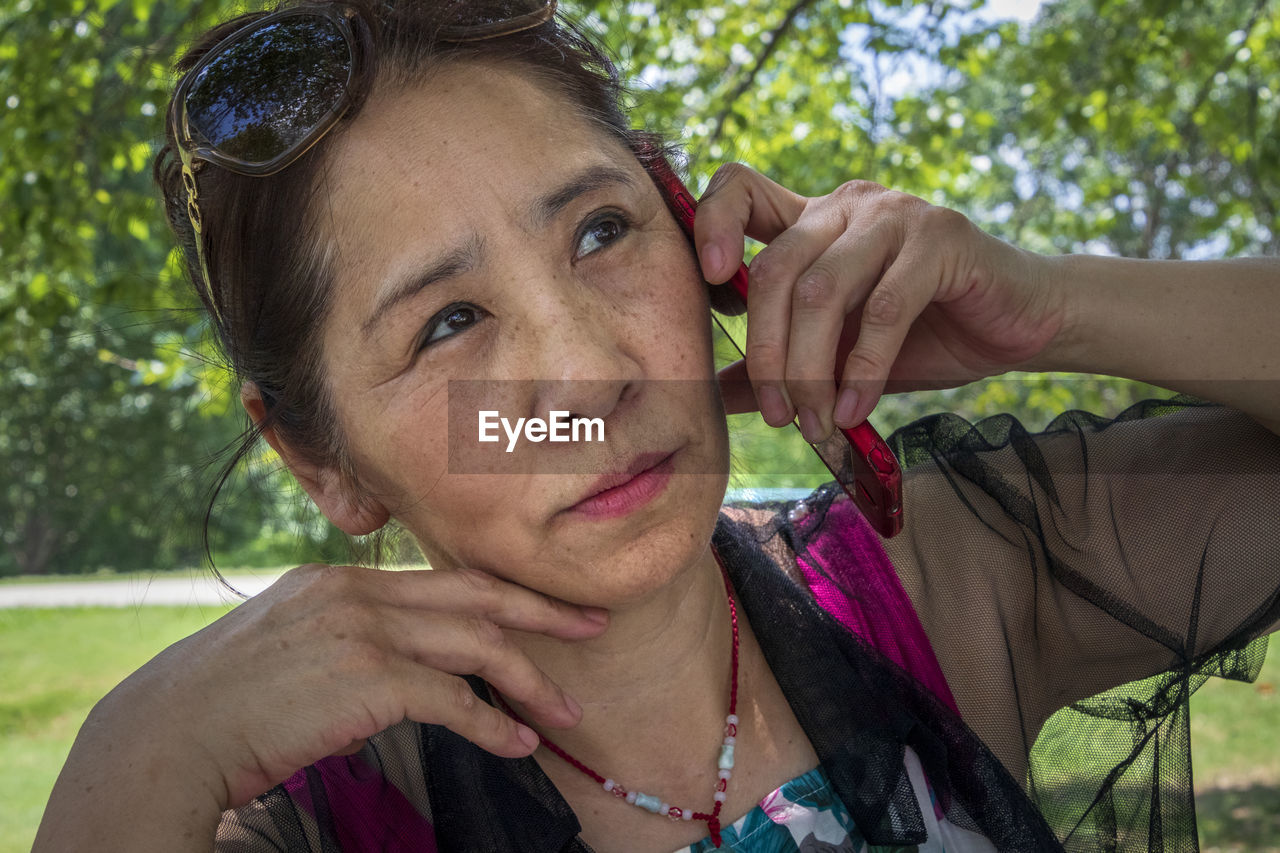 CLOSE-UP PORTRAIT OF A WOMAN HOLDING CAMERA