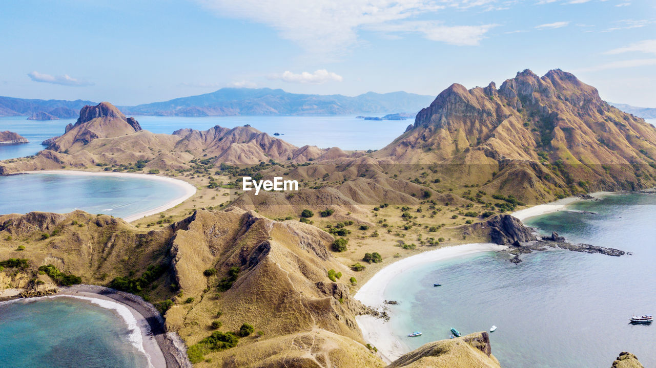 Scenic view of sea and mountains against sky