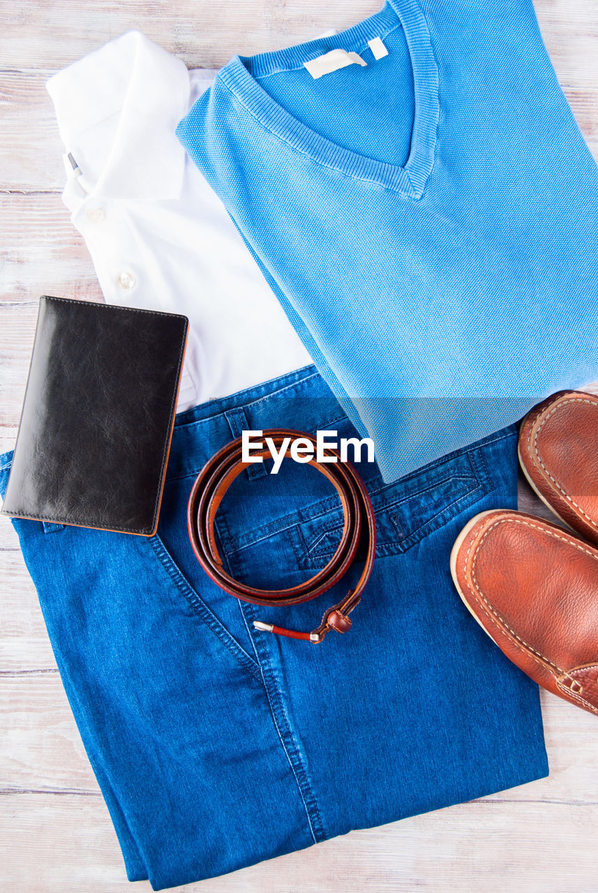 HIGH ANGLE VIEW OF LEATHER SHOES ON BLUE TABLE