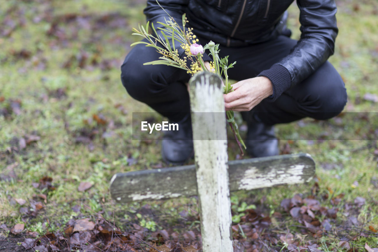 Man with flowers on graveyard, skogskyrkogarden, stockholm, sweden