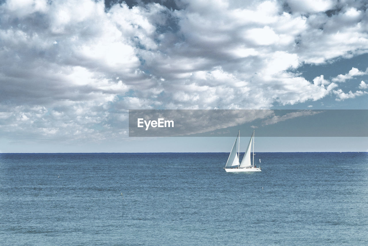 Sailboat sailing on sea against sky