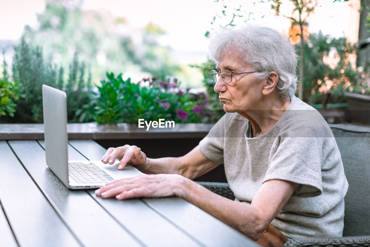 Senior woman using computer at cafe