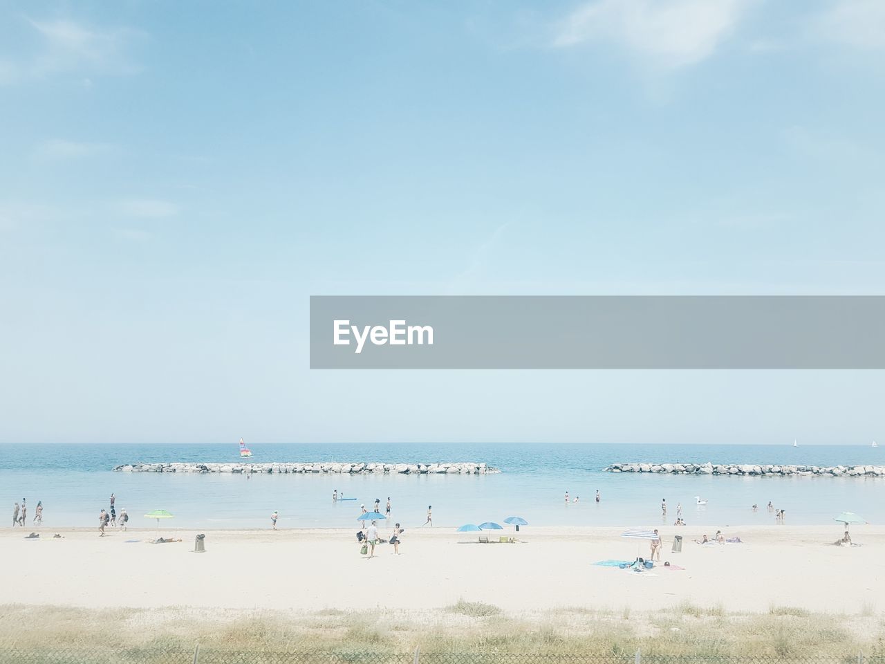 Group of people on beach against sky