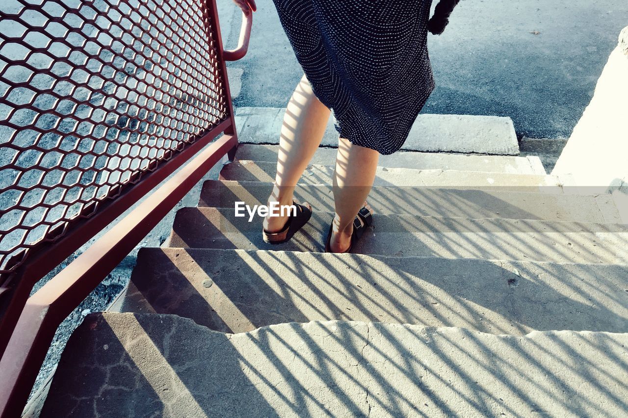 Low section of woman standing on staircase