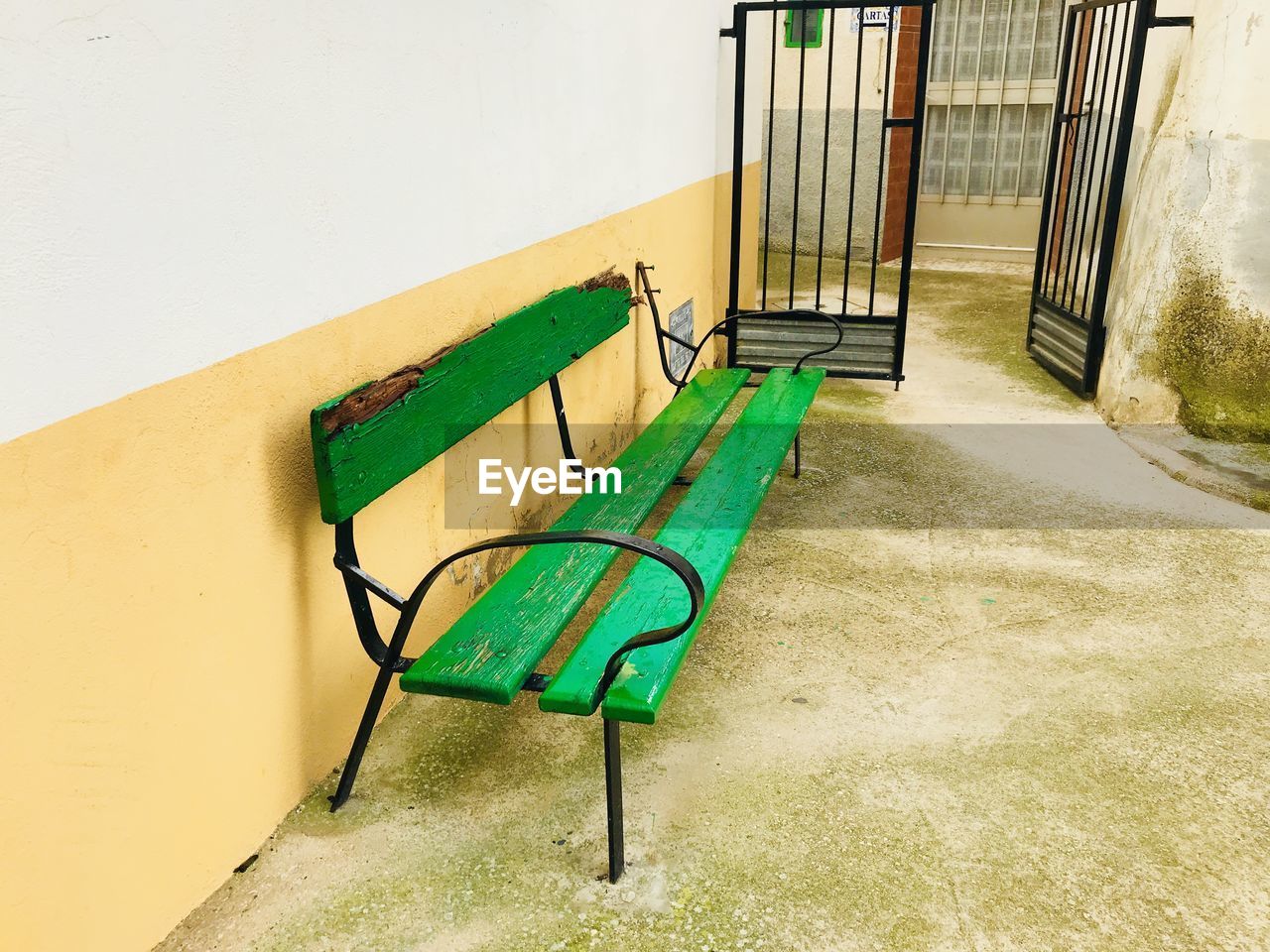 EMPTY CHAIRS ON WALL AGAINST BUILDING