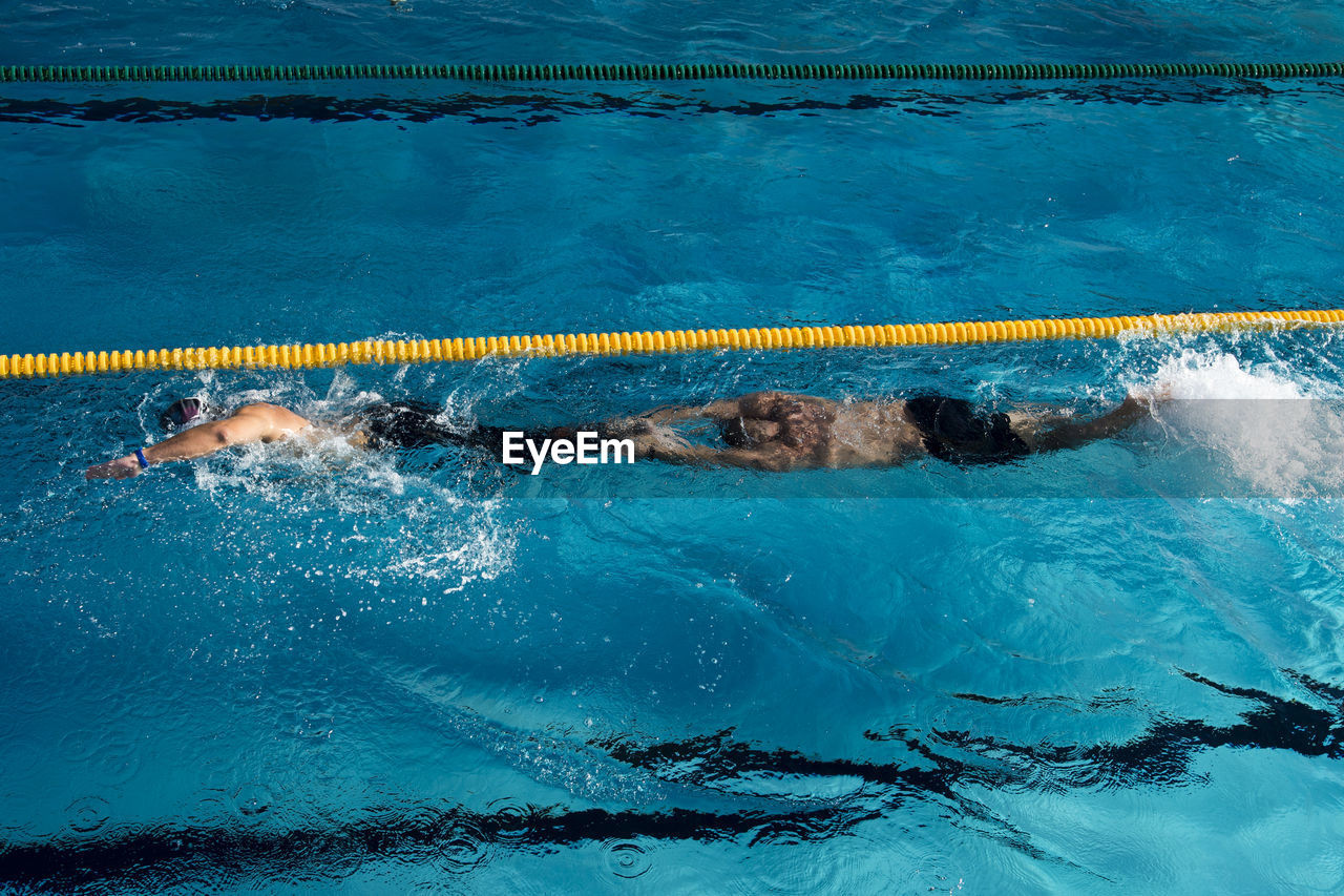 HIGH ANGLE VIEW OF SWIMMING IN SEA