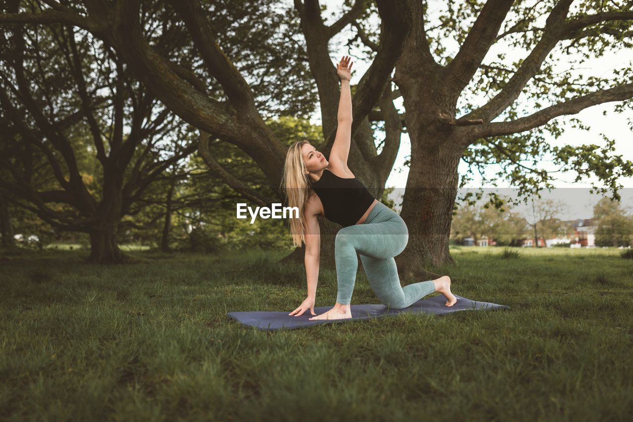 Side view of woman sitting on field