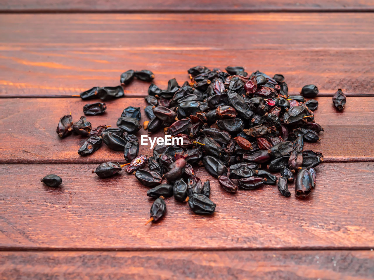 Batch of dry barberries on the background of dark boards.