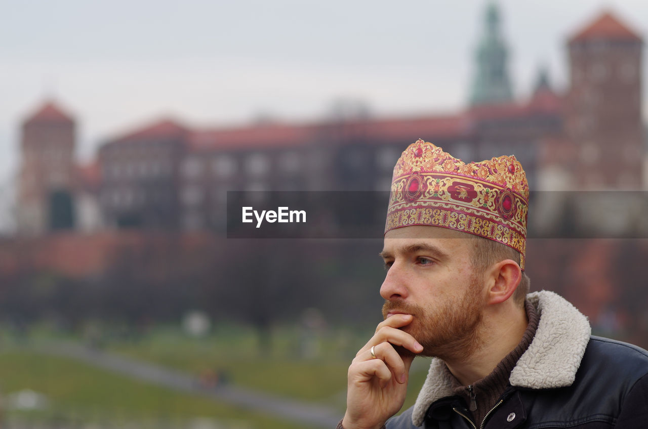 Man with hand on chin looking away outdoors