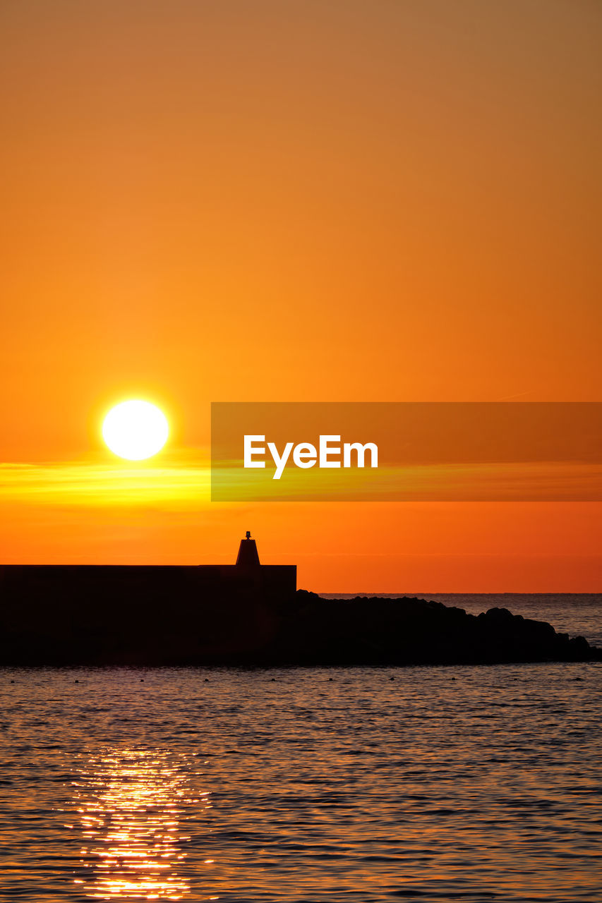 Scenic view of sea against romantic sky at sunset