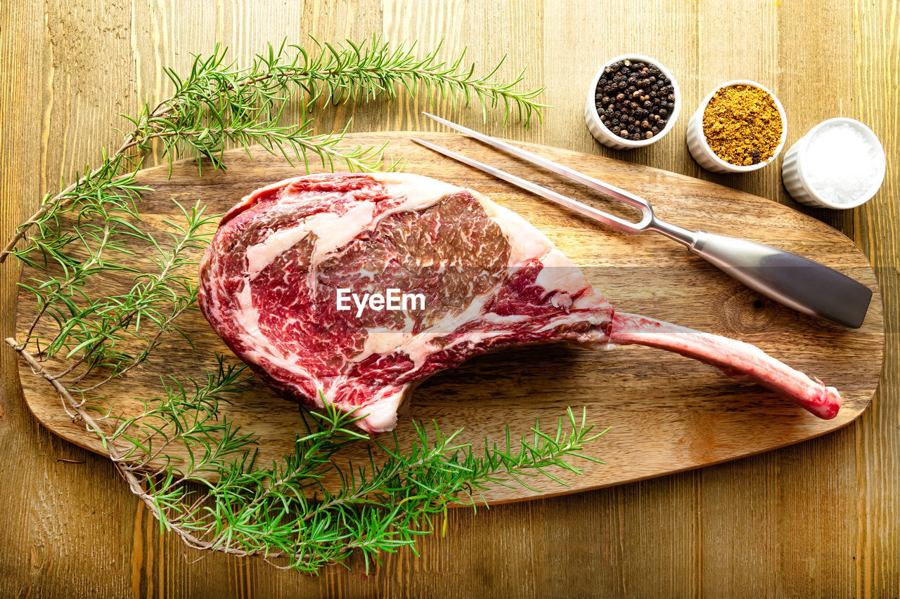Raw waguy tomahawk steak on wooden background with spices ready forthe bbq