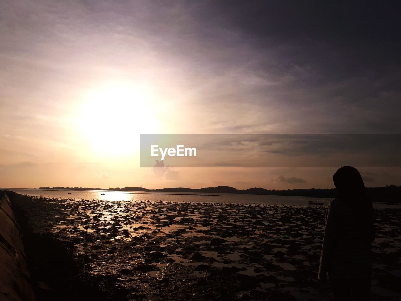 SILHOUETTE PERSON LOOKING AT SEA DURING SUNSET