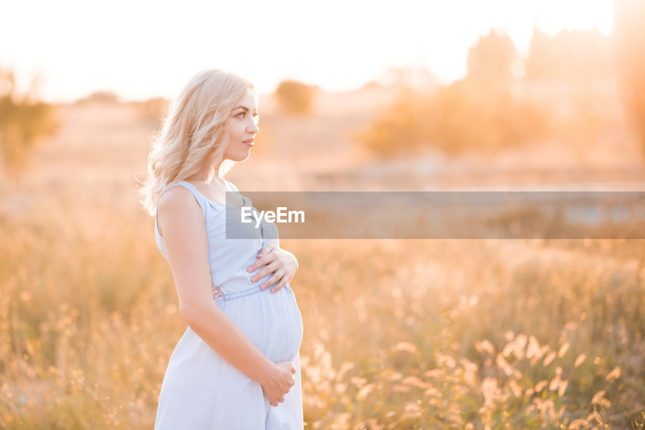 Pregnant woman standing in field