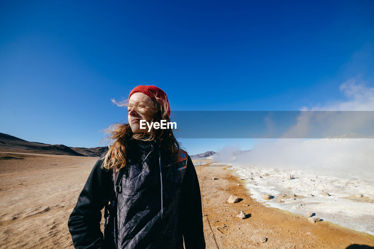 PORTRAIT OF YOUNG WOMAN STANDING IN WINTER