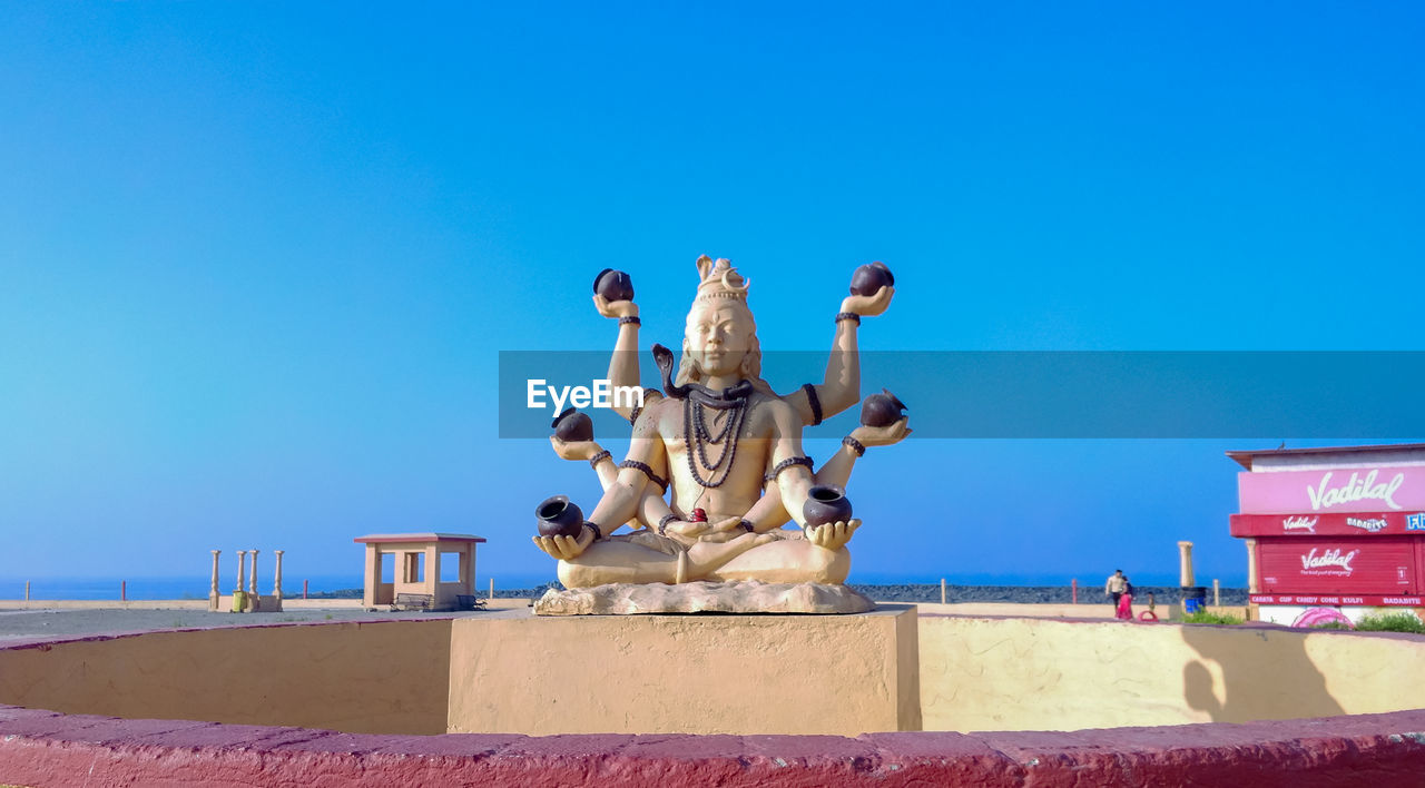 LOW ANGLE VIEW OF STATUE AGAINST BLUE SKY