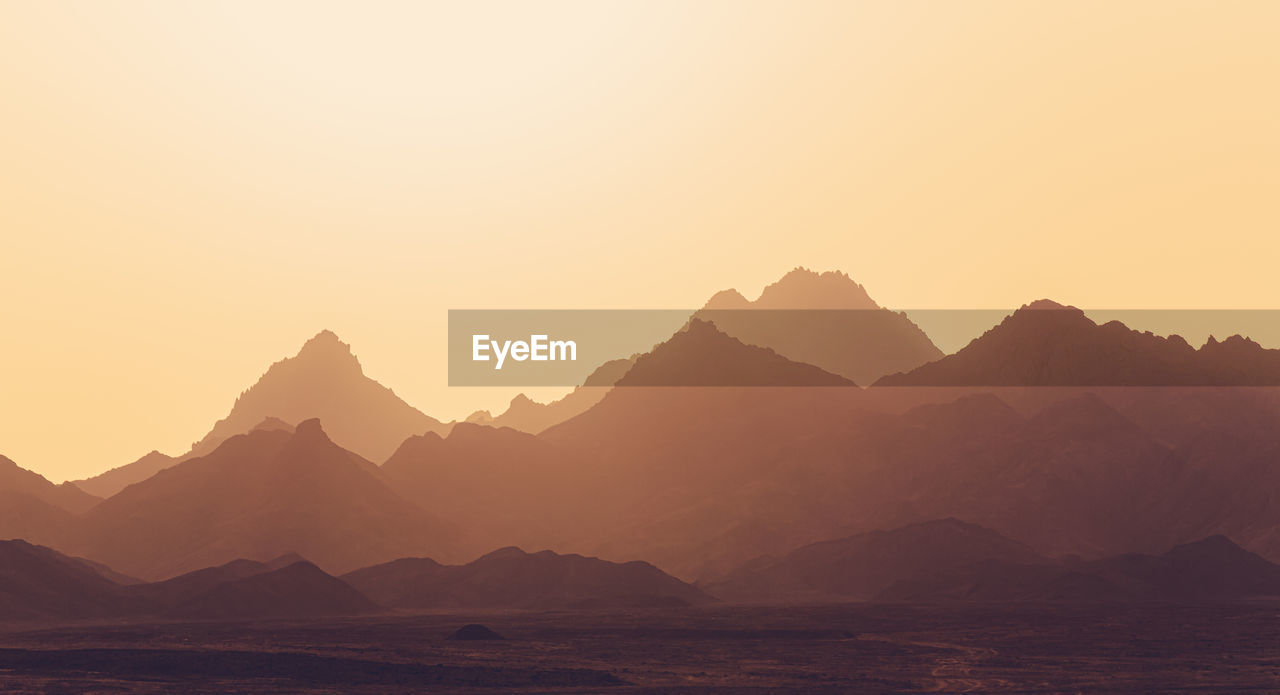 Panoramic view of mountains against clear sky during sunset