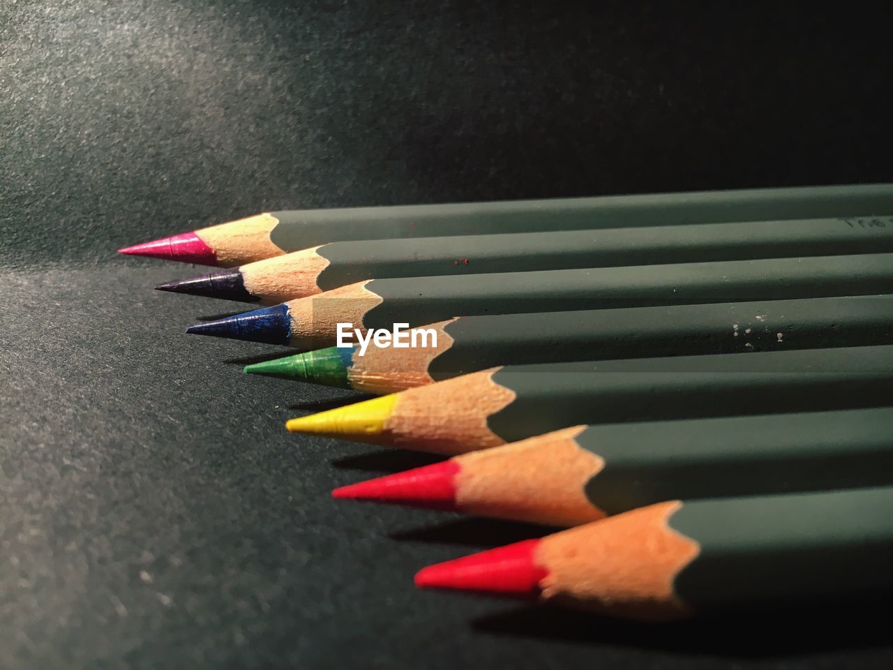 Close-up of colorful pencils arranged on table