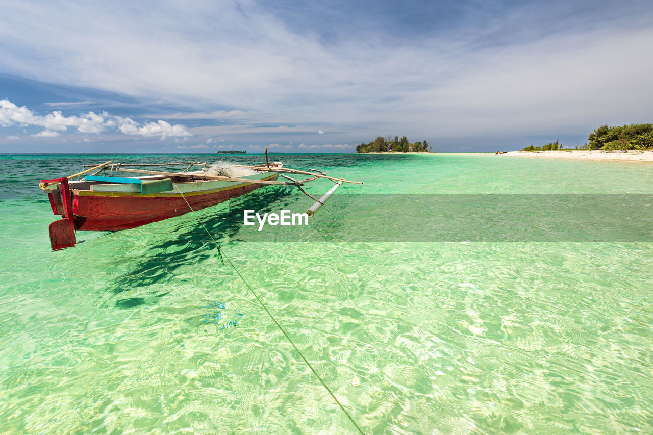 PANORAMIC VIEW OF BOATS MOORED ON BEACH AGAINST SKY