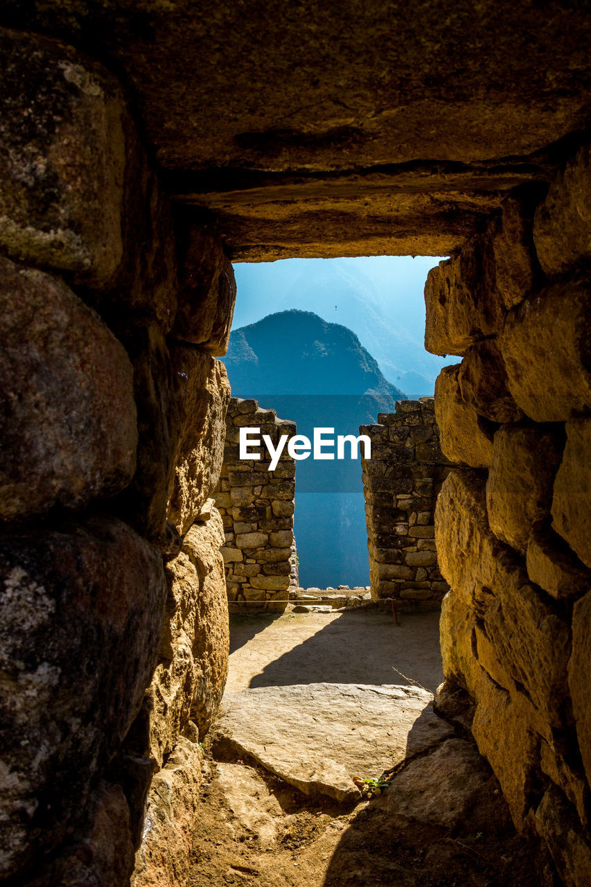 STONE WALL AGAINST SKY SEEN THROUGH ARCH WALLS