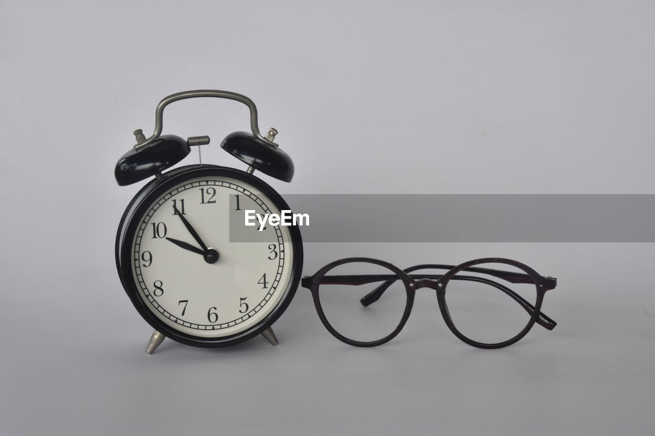 clock, time, alarm clock, indoors, studio shot, no people, clock face, number, still life, minute hand, instrument of time, deadline, single object, copy space, close-up, eyeglasses, simplicity