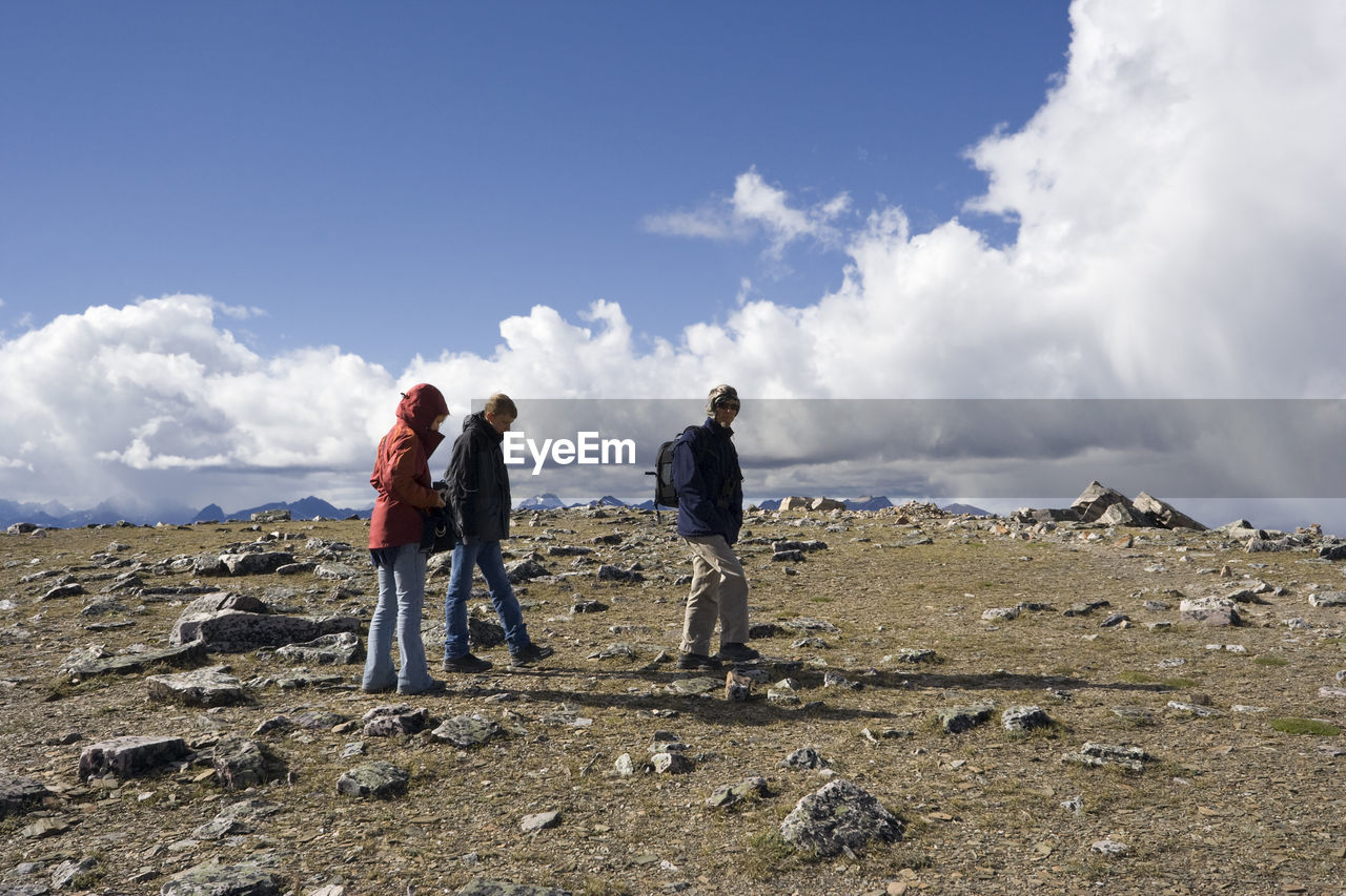 Friends hiking at jasper national park against cloudy sky