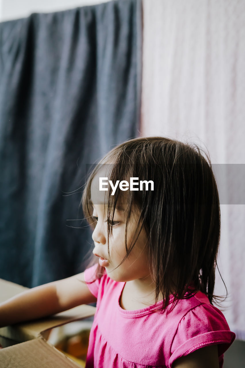 Close-up of girl with cardboard box at home