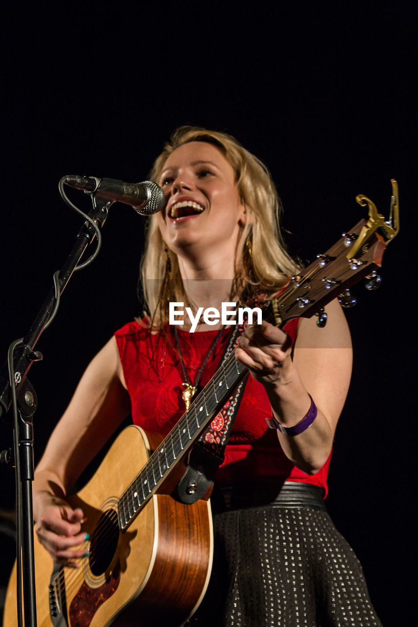 YOUNG WOMAN LOOKING AT MUSIC CONCERT