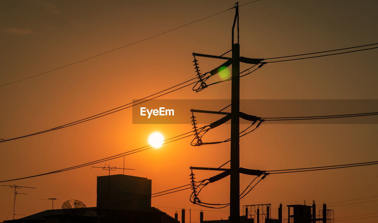 LOW ANGLE VIEW OF SILHOUETTE ELECTRICITY PYLONS AGAINST ROMANTIC SKY