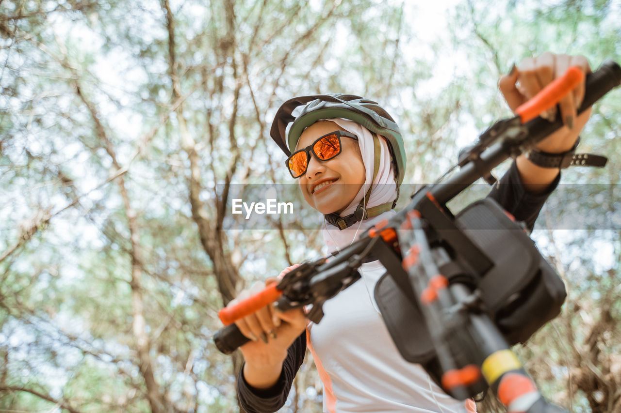 Low angle view of man holding camera