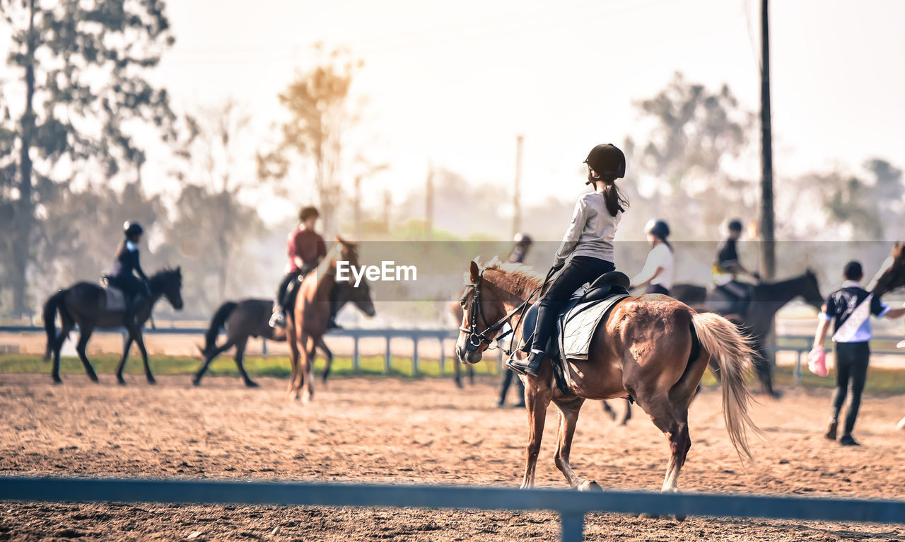 People riding horses in ranch