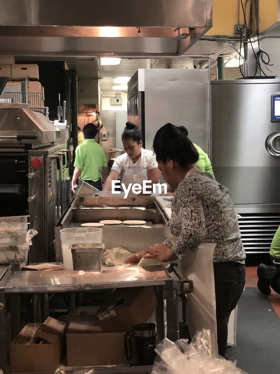 GROUP OF PEOPLE WORKING IN KITCHEN AT OFFICE