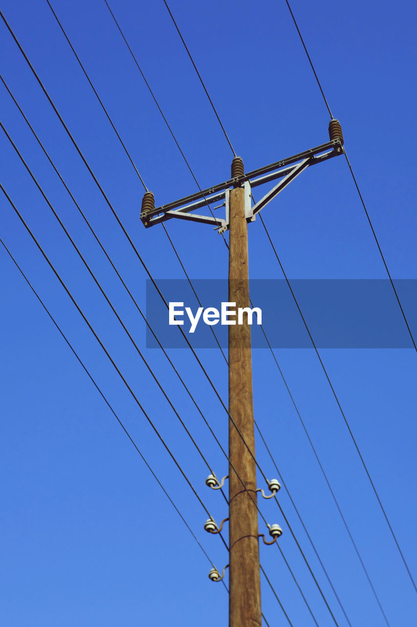 Electricity pylon against clear blue sky