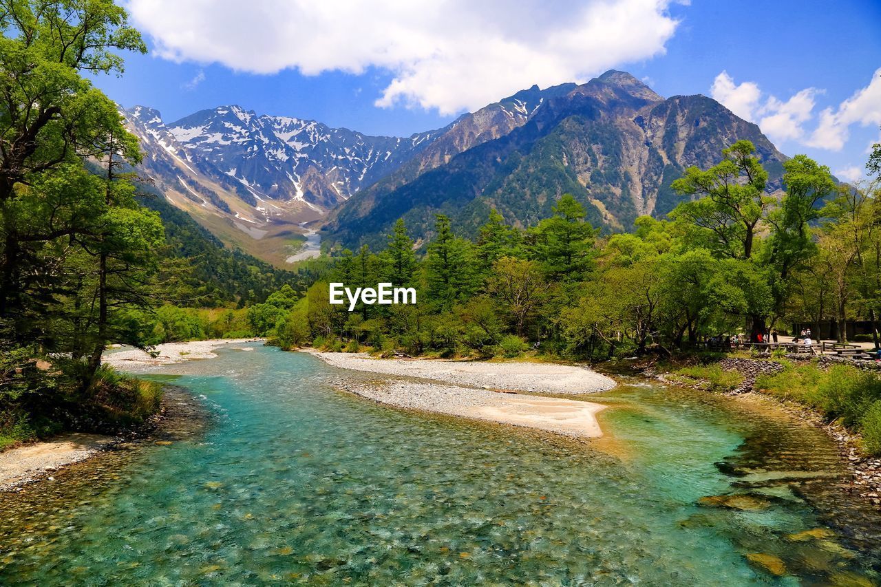 Scenic view of river flowing towards mountains