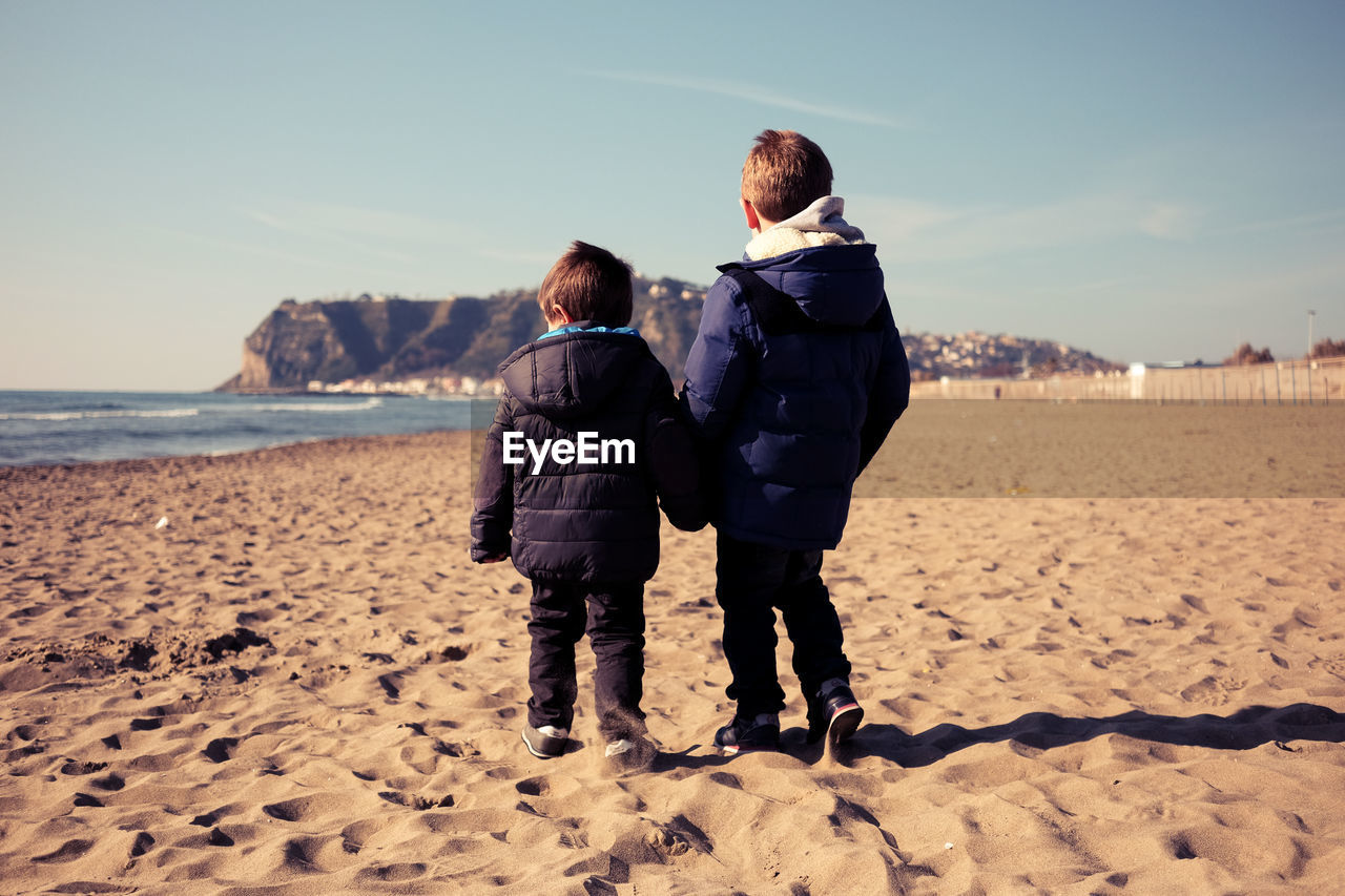 Rear view of children on beach