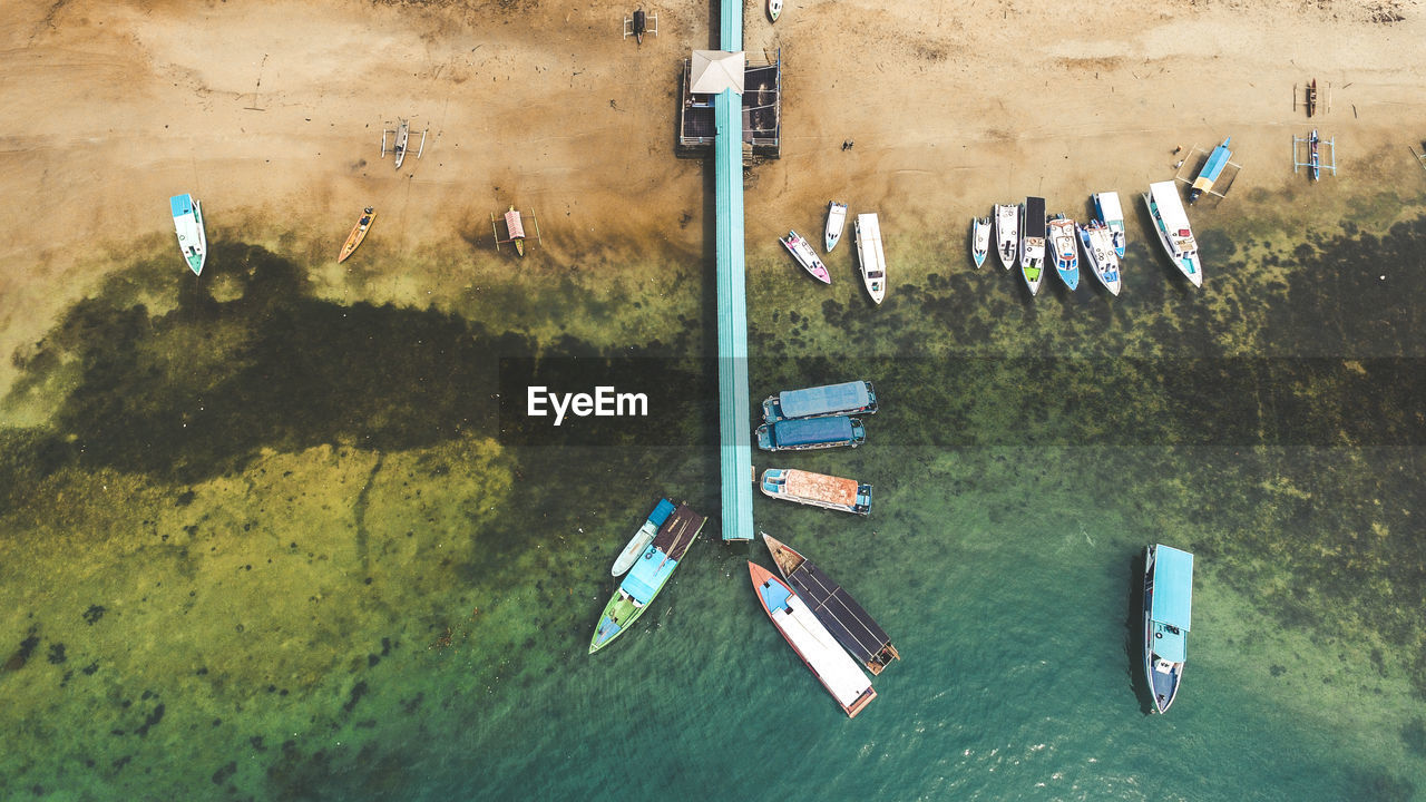 HIGH ANGLE VIEW OF BOATS MOORED AT SEA SHORE