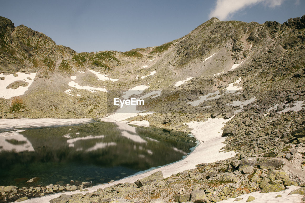 SCENIC VIEW OF LAKE AMIDST MOUNTAINS AGAINST SKY