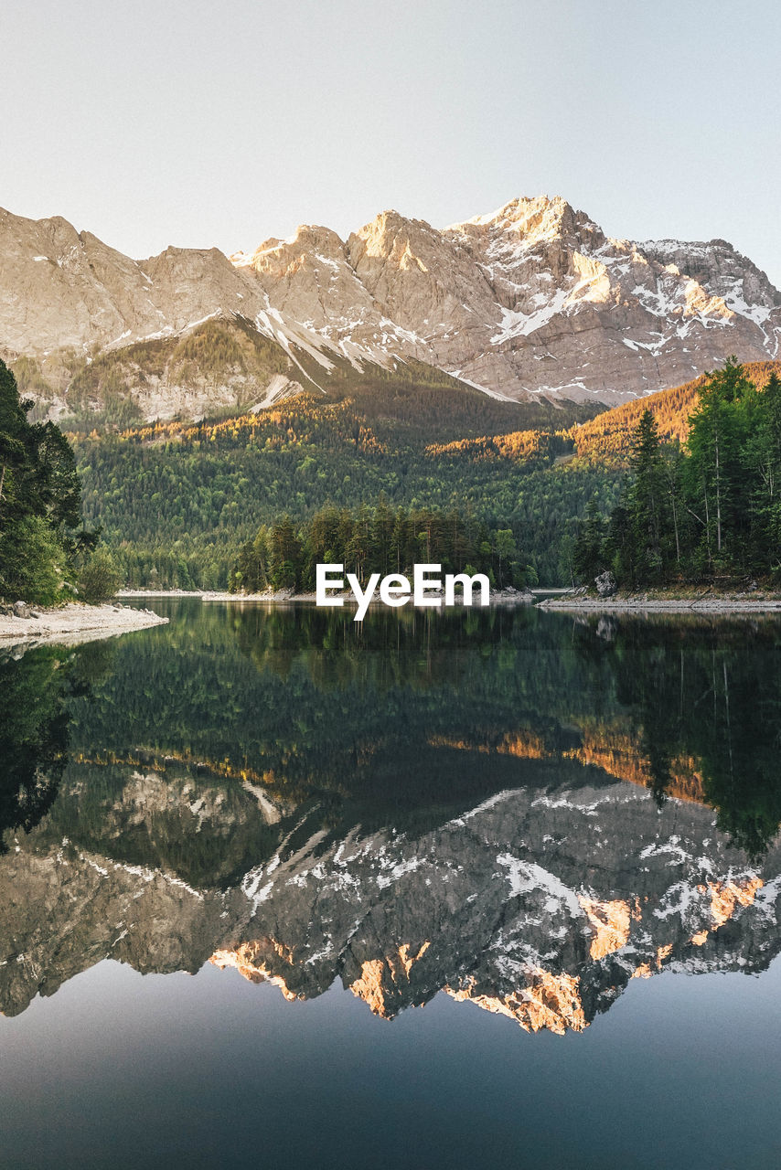 Scenic view of lake by mountains against clear sky