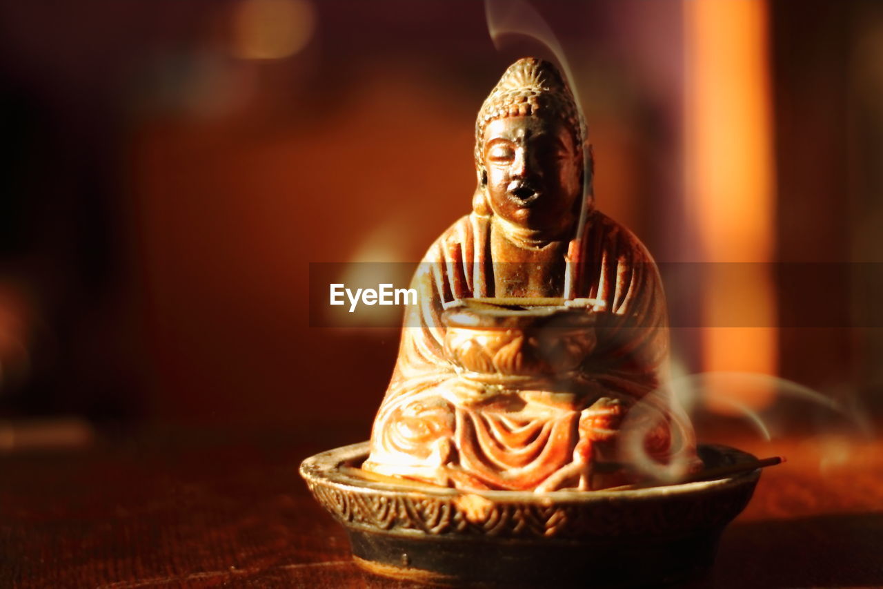 CLOSE-UP OF STATUE ON TABLE AT TEMPLE