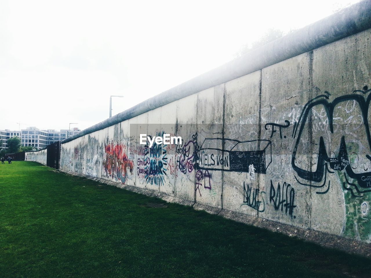 Graffiti on berlin wall against sky