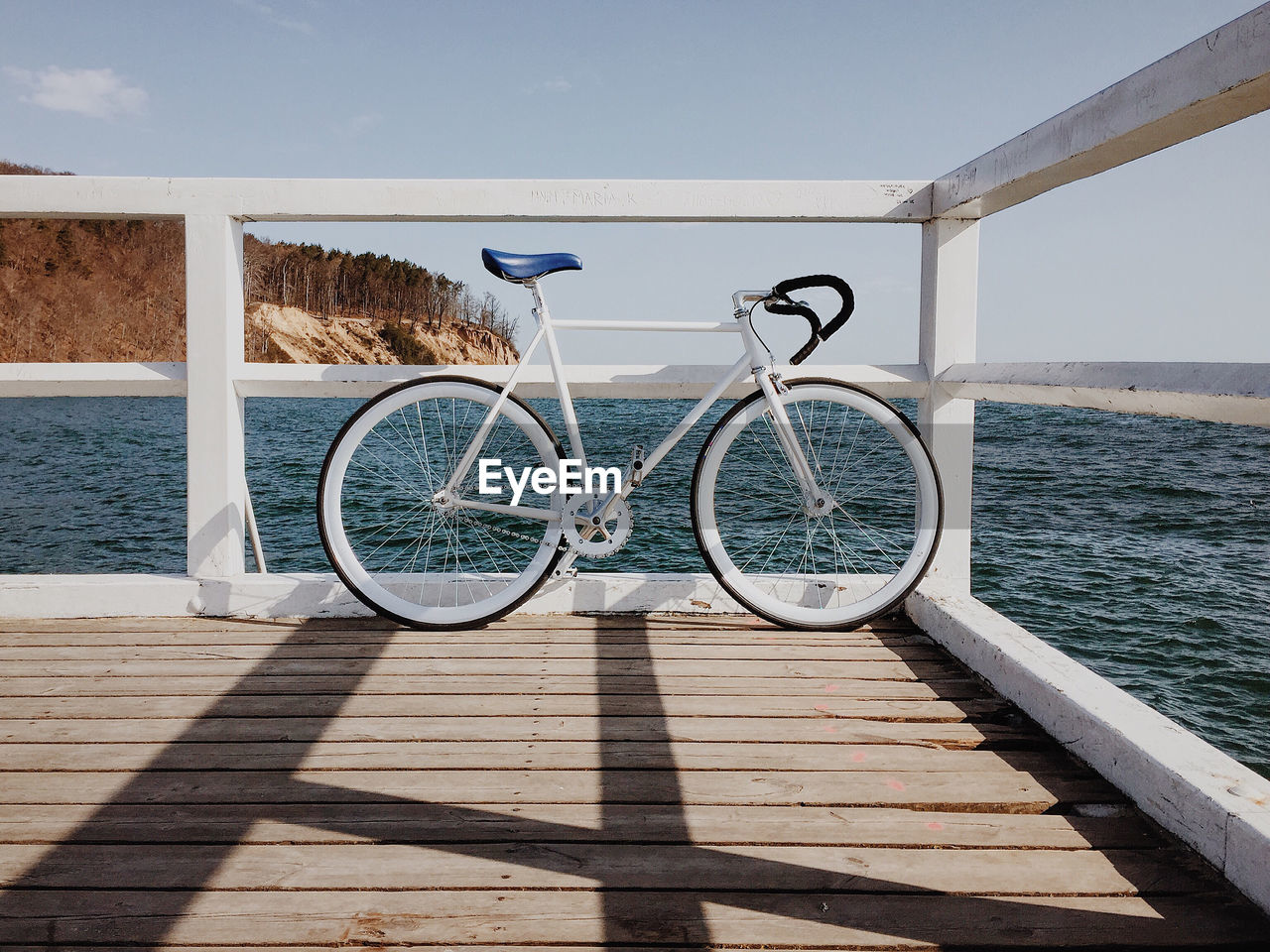 Bicycle parked on pier by sea