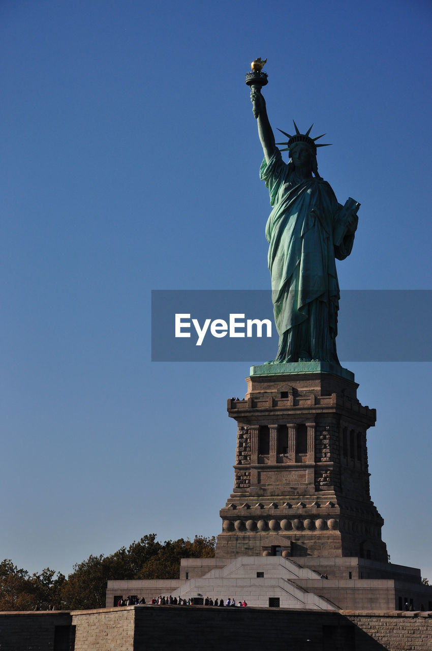 Vertical shot of statue of liberty in new york against a blue sky