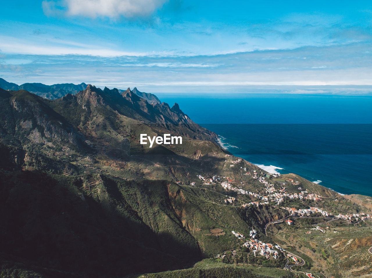 Scenic view of sea and mountains against sky