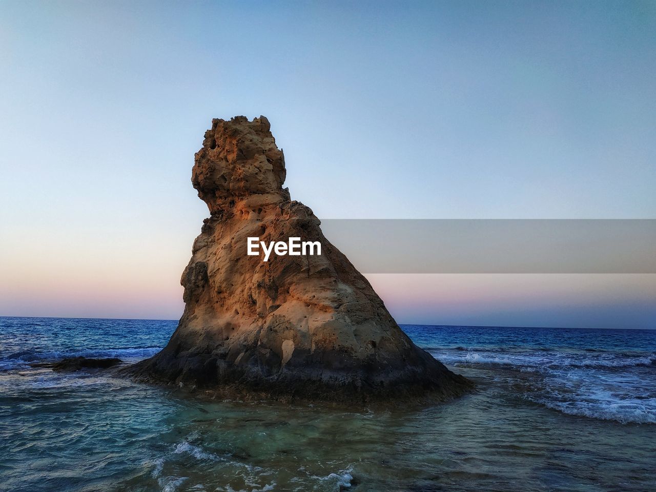 Rock formation on sea against sky