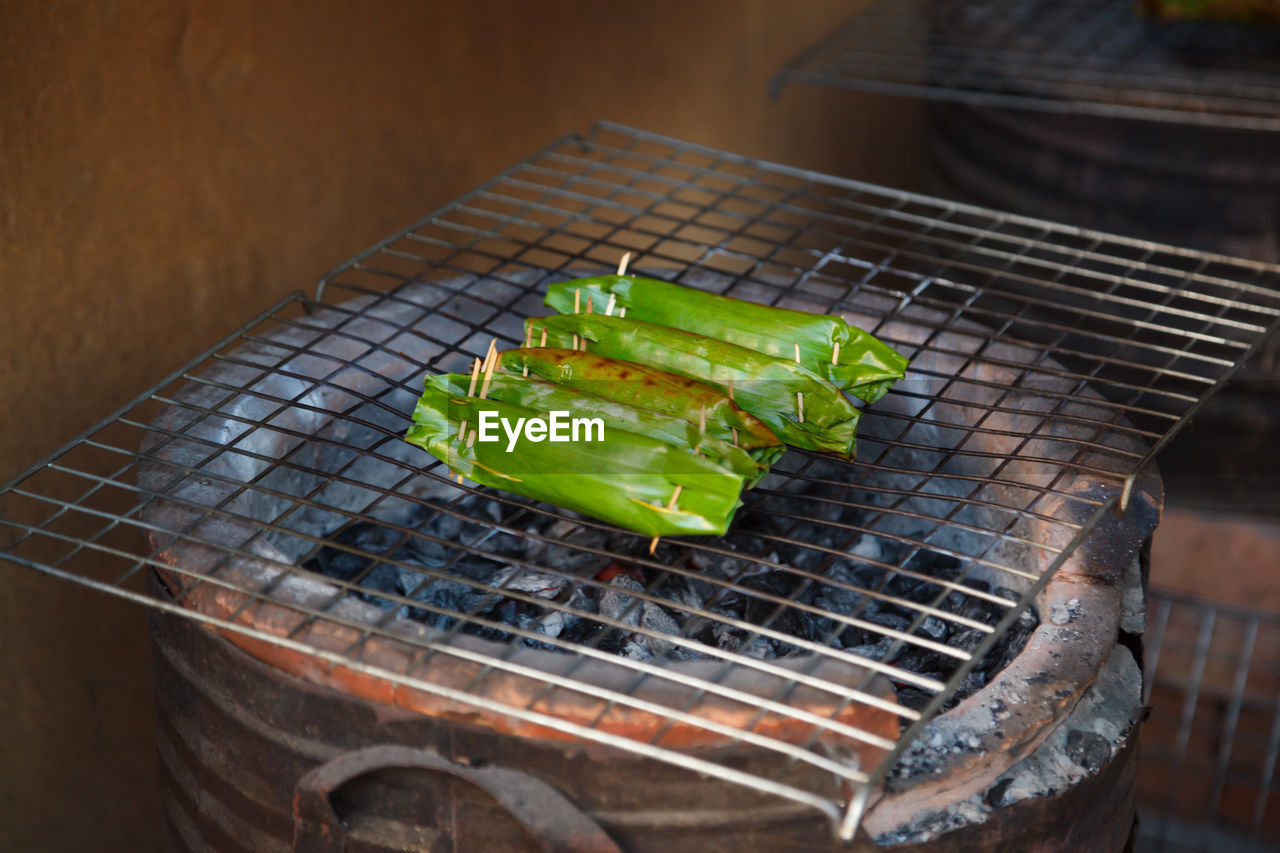 HIGH ANGLE VIEW OF MEAT ON METAL GRILL