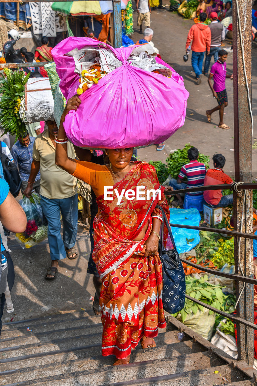 REAR VIEW OF PEOPLE WALKING IN RAIN