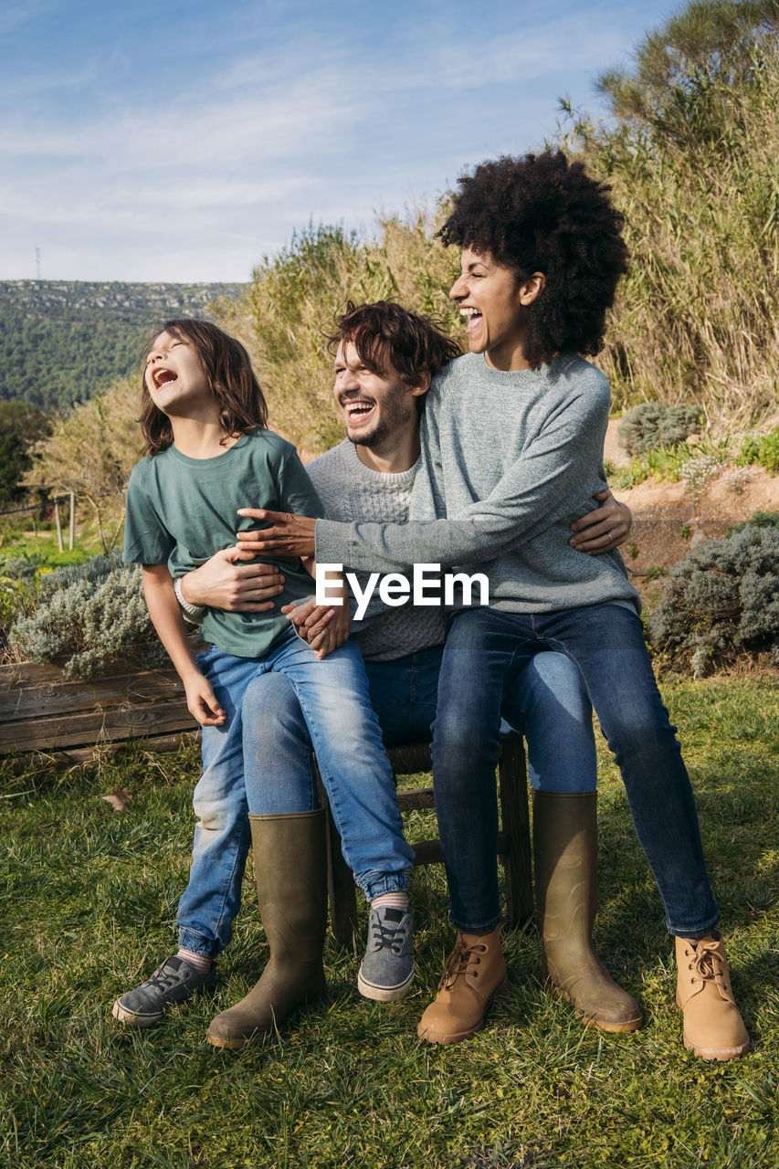Happy family sitting on a bench in a garden