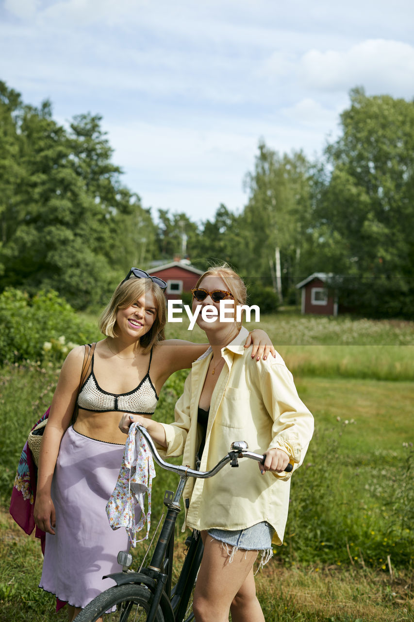 Two friends standing with bicycle