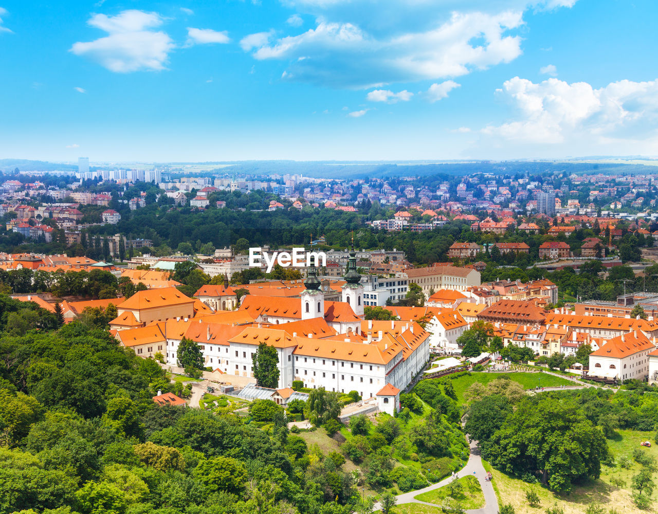 HIGH ANGLE VIEW OF TOWNSCAPE AND TREES AGAINST SKY