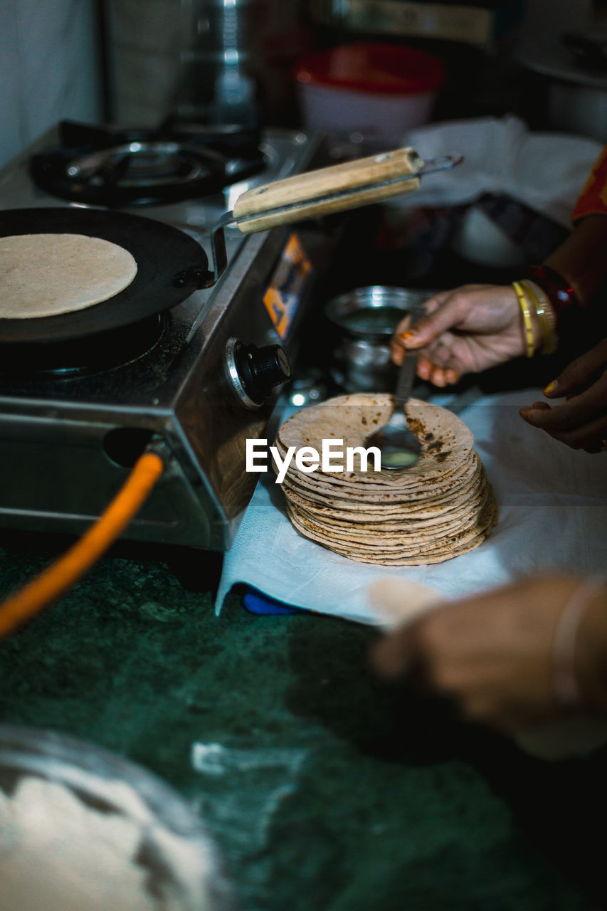 Cropped hand of woman preparing food in kitchen